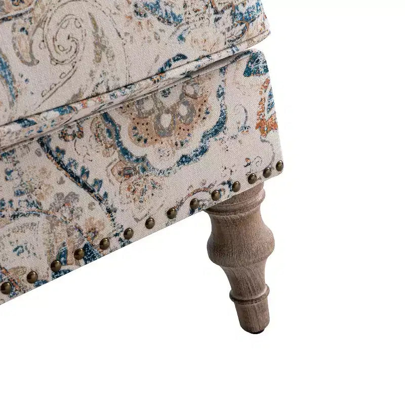 Fauteuil rembourré en bois avec motif floral, accoudoirs à panneaux et dossier en forme de bosse de chameau.